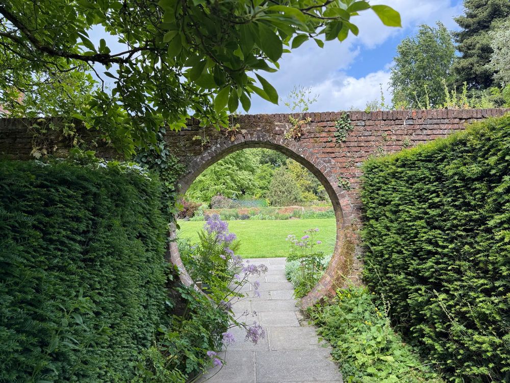 A circular opening in a garden wall