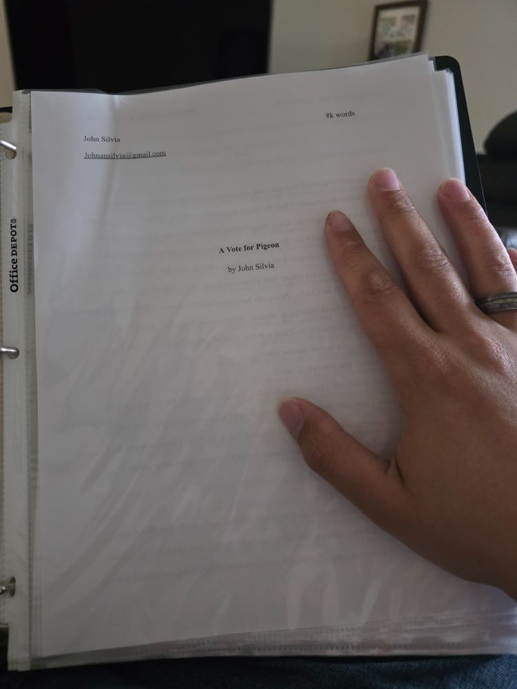 Me placing my hand on a laminated draft of "A Vote for Pigeon", my latest short story.