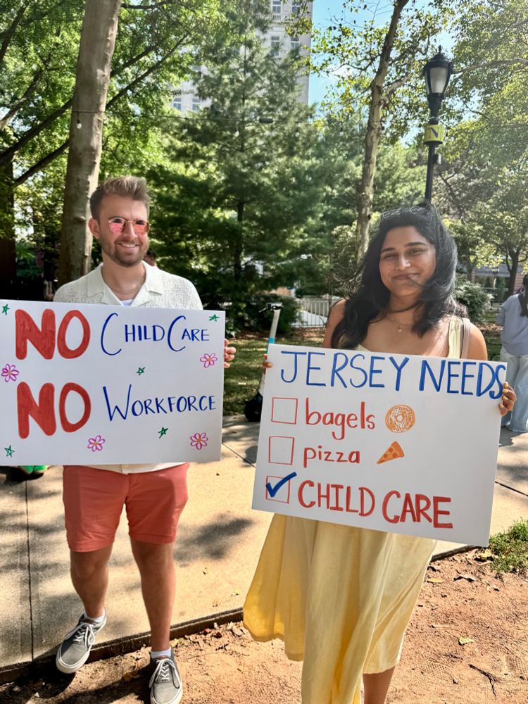 A man and woman holding rally signs about child care.