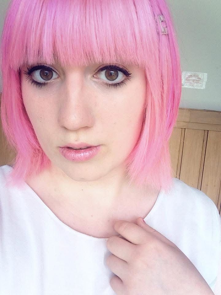 Me with a pound of makeup a pound of eyelashes light pink hair and a plain white shift 