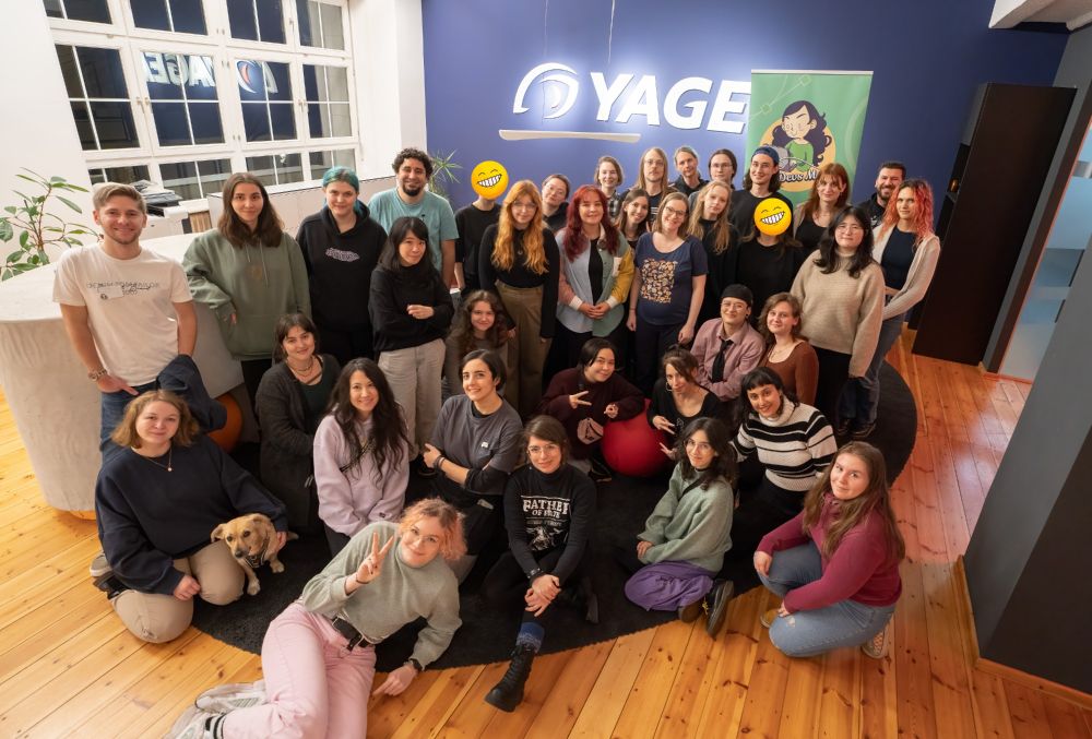 A group of people posing for the camera in the entrance of the Yager Development GmbH office.