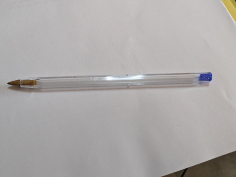 A blue BIC pen, empty of its ink
