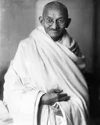 Picture of Gandhi with his white (unsure of colour) robe and hands folded. He also has a moustache and his glasses on his face