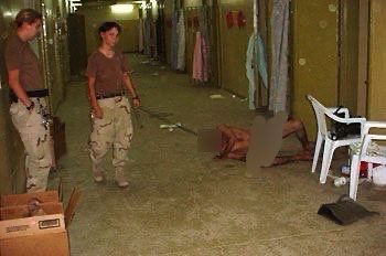 Lynndie England harassing and torturing a different man at Abu Ghraib with another female guard