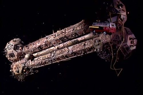 The Satellite of Love from the show "Mystery Science Theater 3000".

In space, an elongated bone-shaped space ship covered in random bumps and nicks. An umbilical at one end is attacked to a floating toy RV. 