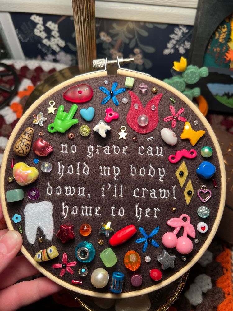 chaotic charm/trinket embroidery piece with lyrics from hozier’s song “work song”