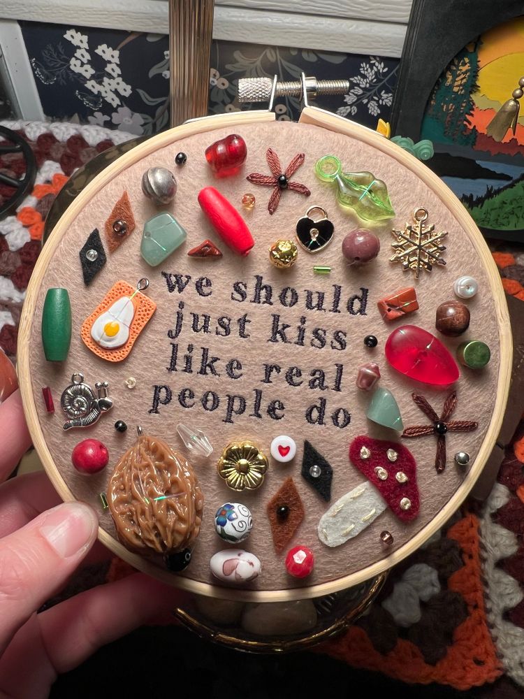 chaotic charm/trinket embroidery piece with lyrics from hozier’s song “like real people do”