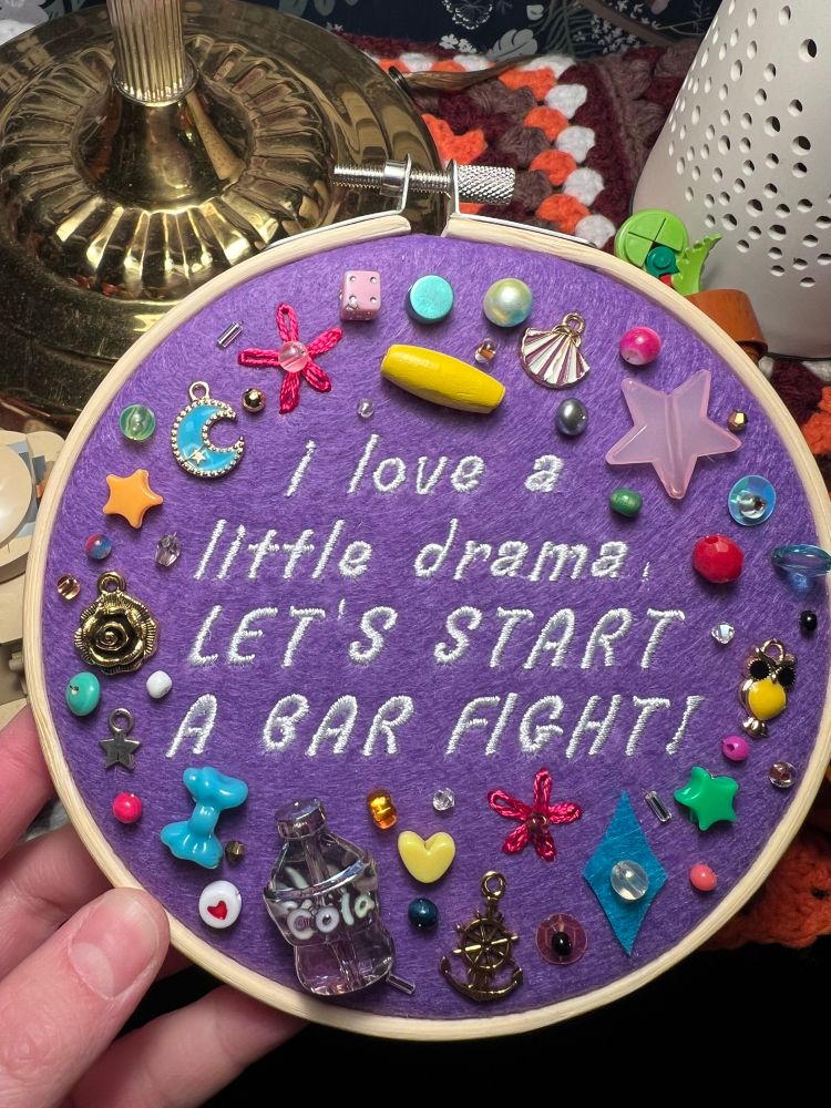 chaotic charm embroidery hoop with lyrics from chappell roan’s song “after midnight”: “I love a little drama, let’s start a bar fight”