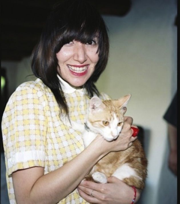 Karen O with a huge smile as she holds a cat.