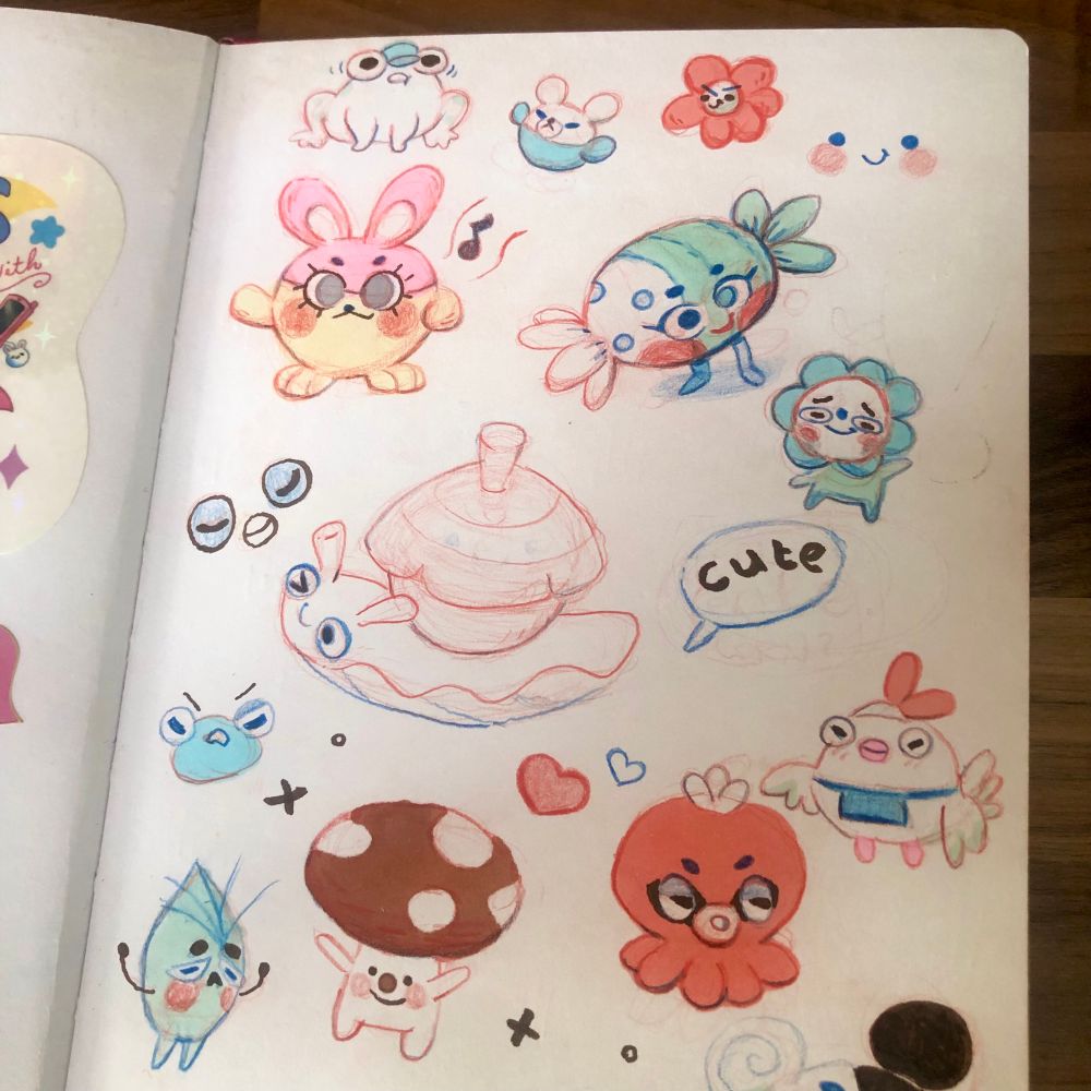 An open sketchbook photo with lots of cute little doodles! There are many characters, such as a chicken in an apron, a happy mushroom, two frogs, an octopus and much more :) 