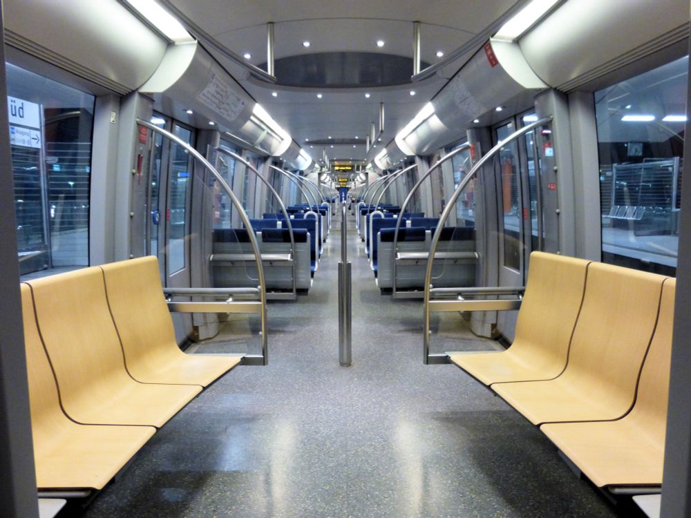 Picture of a Munich U-Bahn C stock train, featuring very large windows and beautiful light laminated wood longitudinal seating 