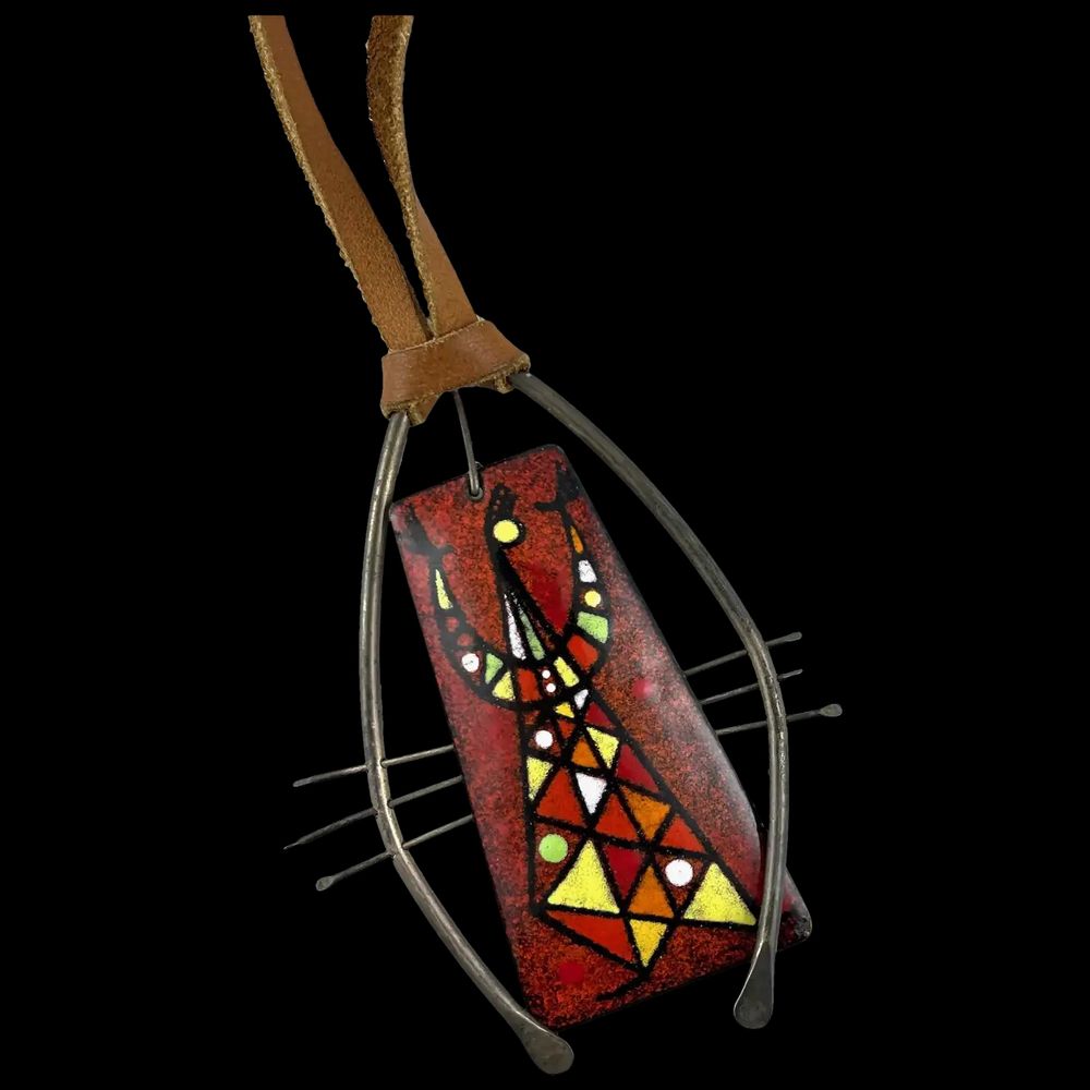 A huge one of a kind vintage 1950s handmade sterling silver copper enamel modernist pendant on cord necklace by San Diego artist/craftsman Barney Reid (1913-1992). A very large quite rare and outstanding example of the modernist enamel art created by this important California artist from the mid 20th century! Truly wearable art! A founding member of San Diego’s Allied Craftsmen, Reid was a talented artisan and prolific in many media including metal, clay, wood, and marble, as well as oil painting and furniture design. A selection was featured in several shows in the 1950s and 60s at New York City’s Museum of Contemporary Crafts, including Enamels in 1959. Reid's work was prominently displayed in the exhibition "San Diego Craft Revolution" at the Mingei Museum in San Diego in 2012. One of Reid's larger works, a multipanel enamel mobile, sold at Christie's in 2016 for over $32K before auction fees and taxes!
Pendant measures 3-1/2" by 2-3/4" wide on a 26" length leather cord that can be re-tied at varying lengths, and weighs 37.2 grams total. Marked at back with artist signature as shown. Excellent vintage condition.