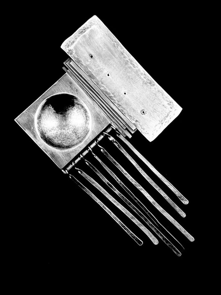 A huge one of a kind vintage 1970s signed handmade sterling silver kinetic modernist brutalist brooch by NYC artist/jeweler Paul Marcero. Entirely handmade hand fabricated and hammered one of a kind piece of wearable modern art! An incredible exercise in composition and craftsmanship, this was a student piece by the artist while at SUNY - Brockport where he graduated from the jewelry/metal arts program. When worn, the long dangles move freely with the movement of the wearer! Here's a short bio of the artist:

Paul Marcero was born in NYC in 1952. He studied under Albert Paley at the State University of New York at Brockport where he graduated in 1974. He studied under Dave Pimentel at Arizona State until 1976. He opened his own workshop in NYC where he was in business for about 20 years. He and his wife moved to Wilkes Barre where he had his own shop for several years, and later freelanced for various jewelers in the area until he retired in 2022. I purchased this brooch directly from the artist, and most of the information here is from him.

Measures 4.75" tall by 2-5/8" wide, and weighs 29.7 grams or just about one ounce total. Marked at back with the artist signature, a conjoined "PM", also "Sterling" and "1973". Excellent vintage condition.