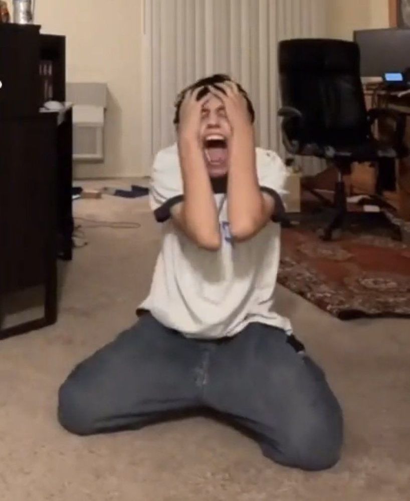 Guy screaming, kneeling, crying, on the carpet floor