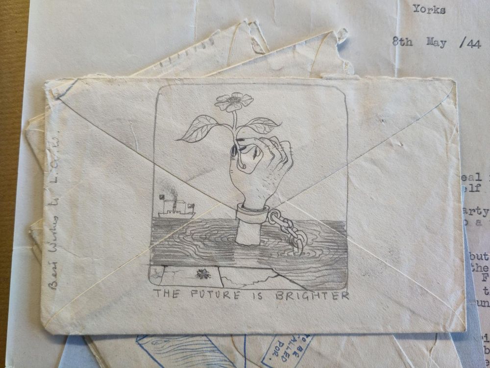 Envelope with a pencil illustration representing a hand in shackles emerging from the sea, holding a flower. The text below the illustration reads: "the future is brighter".