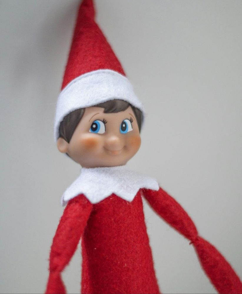 A creepy elf dressed in red looking askance
