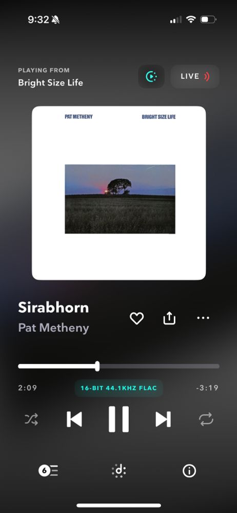 Music player screen on a smartphone showing Pat Metheny’s album “Bright Size Life.” The track “Sirabhorn” is playing, with the progress bar at 2:09 of 3:19. The album cover features a photograph of a lone tree in a field at sunset.