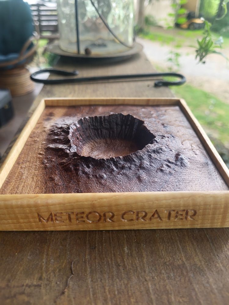 Arizona's Meteor Crater Natural Landmark carved into walnut with hickory frames. 