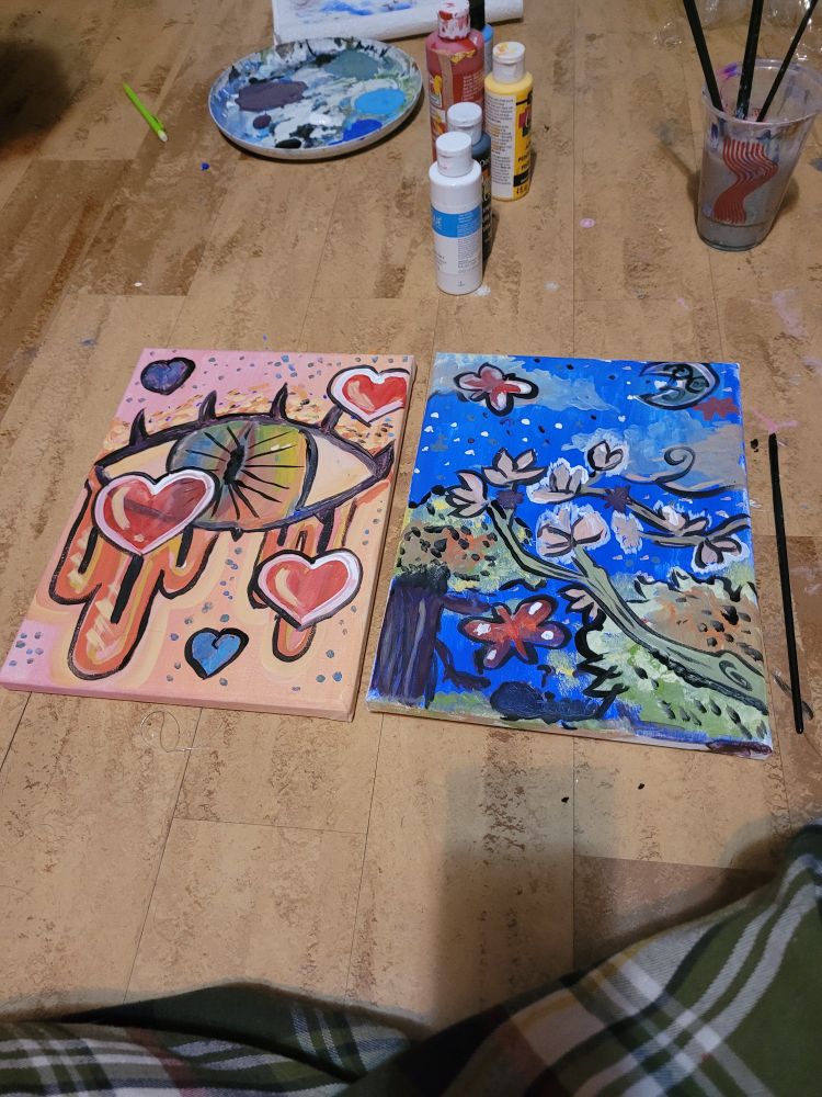 A side by side of two small paintings. Both of them have various doodles, one is a large colorful eye with long eyelashes and the other is various tree branches and flowers. It is apparent these were done quickly as per the challenge. 
