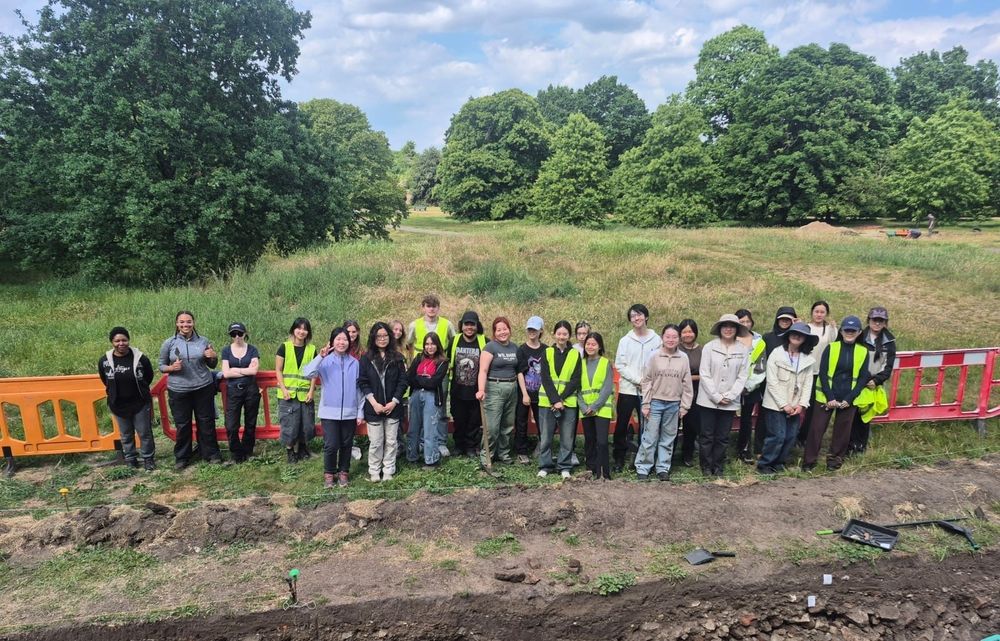 A group of Students pose by an open trench at the Greenwich Royal Park excavations 2025. 