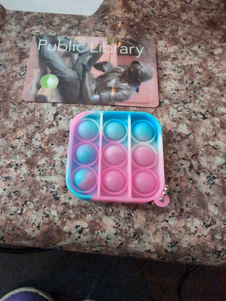 Trans colored stim toy, public library card for scale
