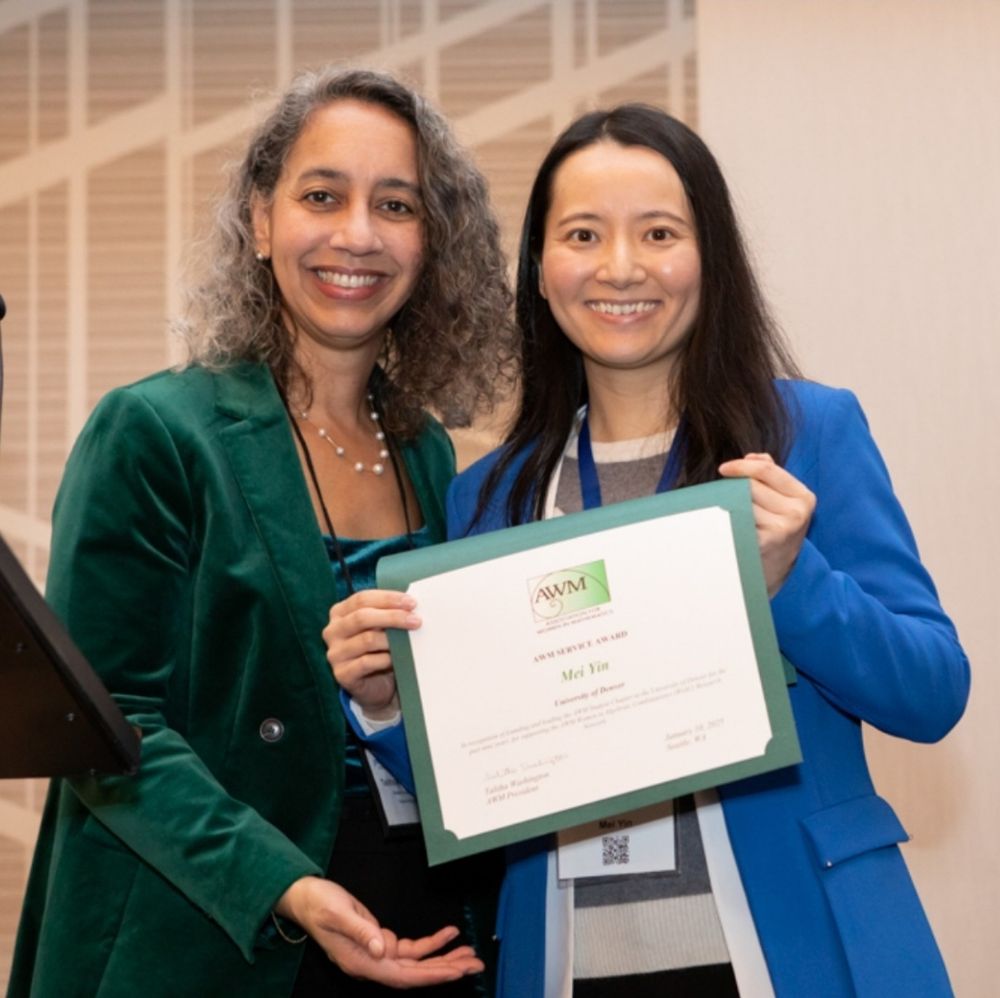 Photo of past AWM president Dr. Talitha Washington with AWM Service Award Winner Dr. Mei Yin of the University of Denver. 