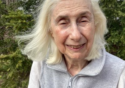 Photograph of Professor Grace Wabha, smiling, and wearing light gray zippered top.
