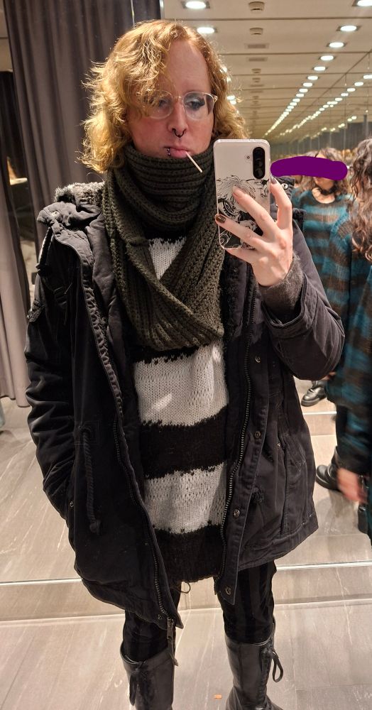 Nyarla in outdoor fit taking a selfie in a changing room