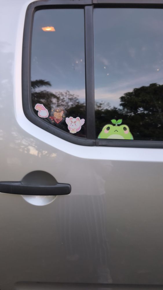 A car door with some stickers on the window