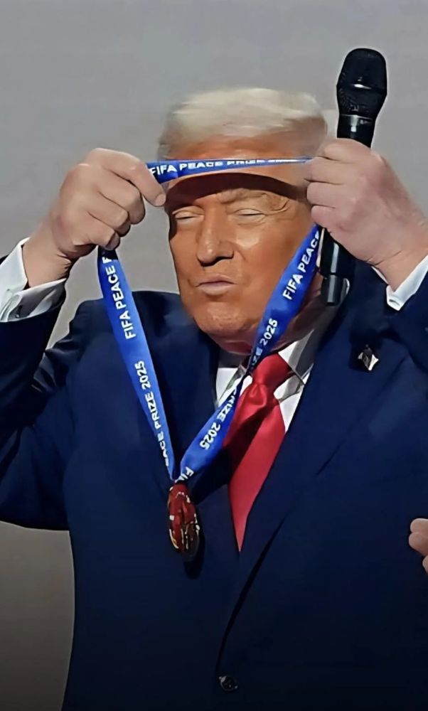 Trump embarrassingly putting a pretend peace prize medal on himself. His orange facial bronzer looking even worse than typical by having hands next to face. 