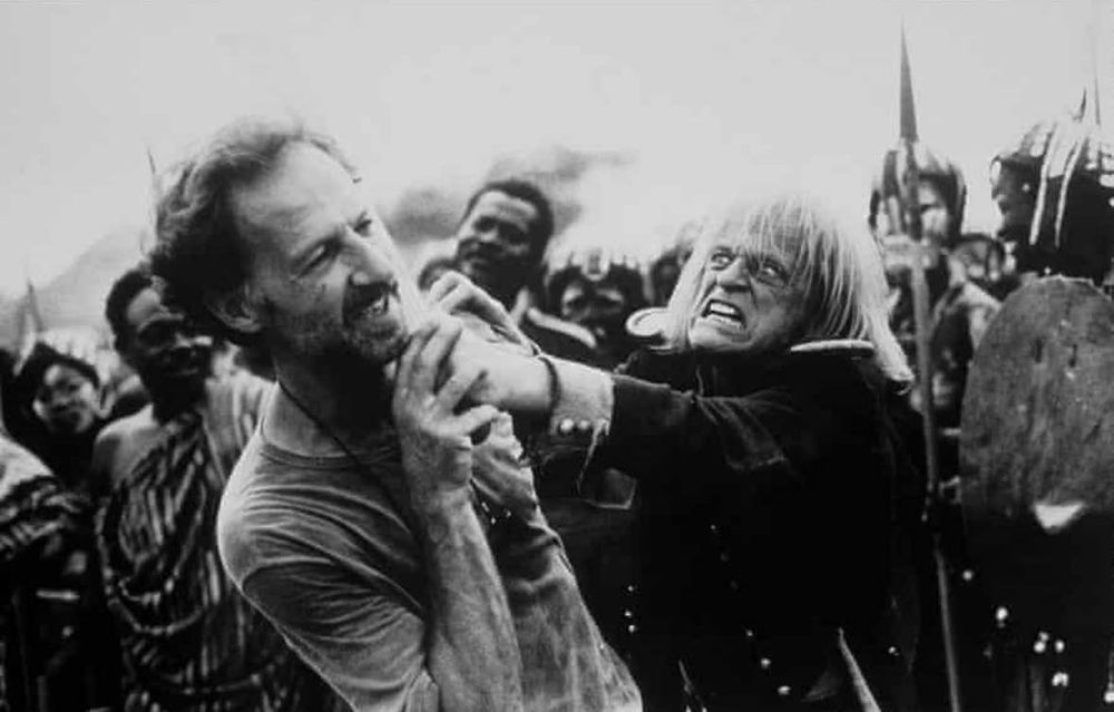 Klaus Kinski holding a machete to the throat of Werner Herzog on the set of Cobra Verde.