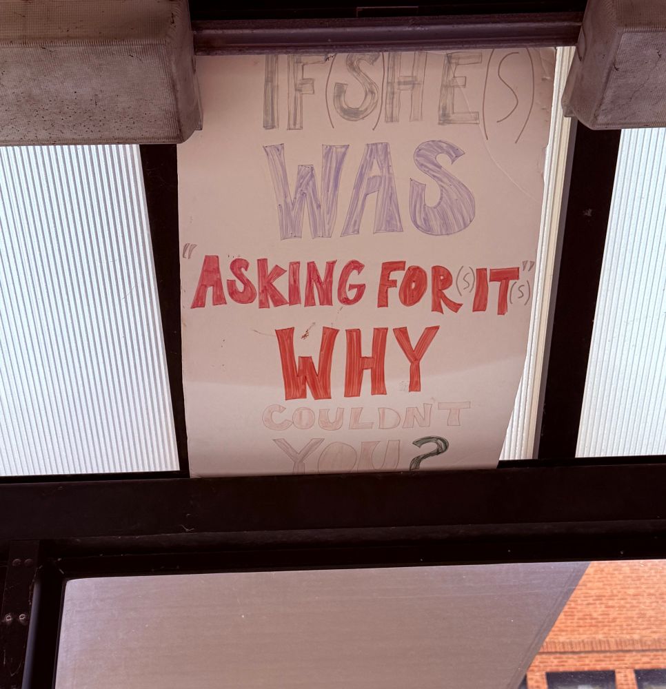 A handwritten sign that says: if (s)he(s) was “asking for it” why couldn’t you?