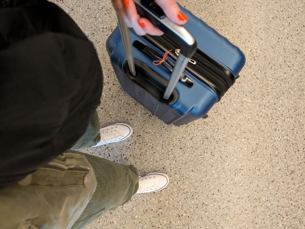 Looking down at a blue suitcase at the train station 