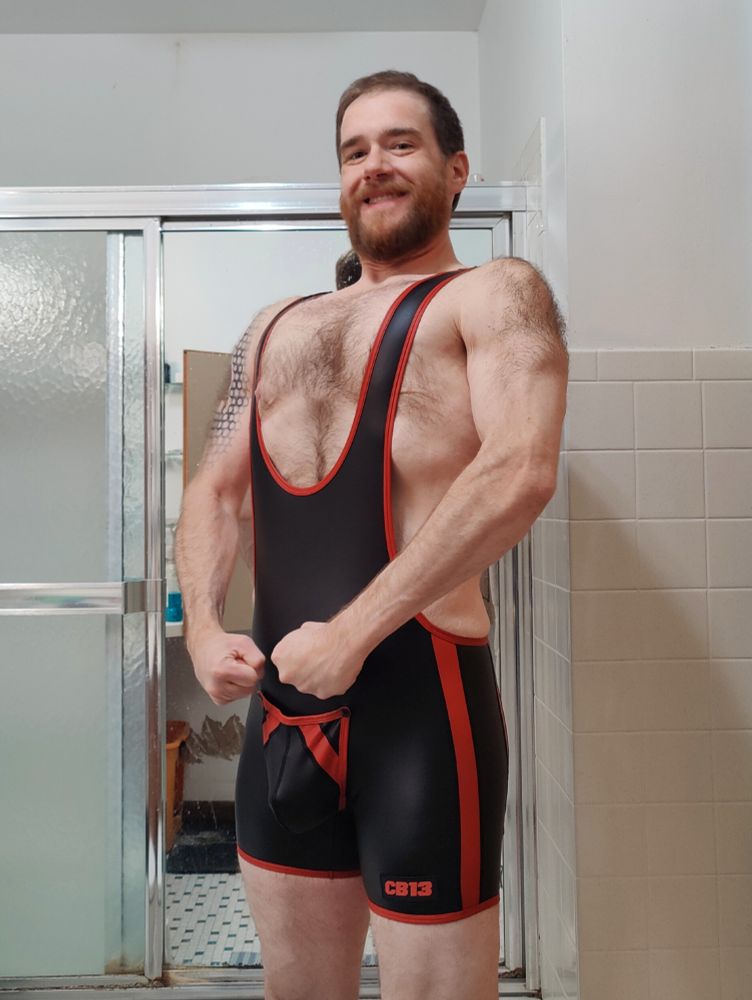 A photo of me posing in a black wrestling singlet with a removable pouch