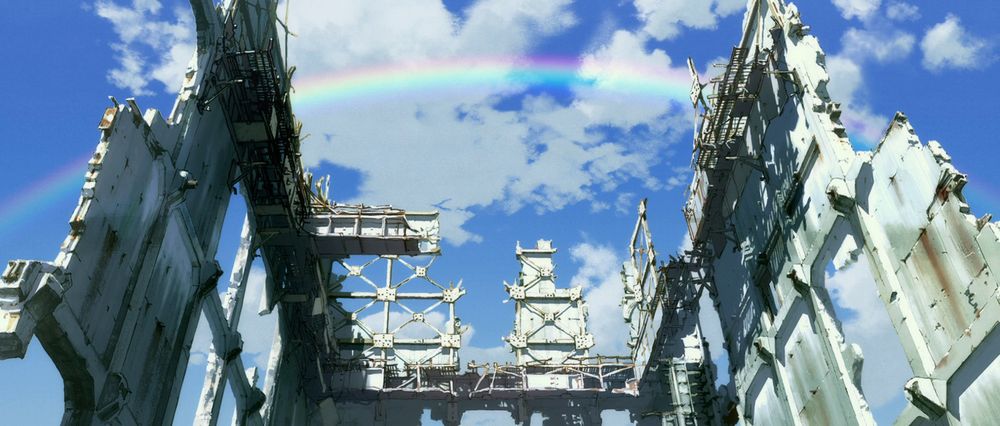 A screenshot from Evangelion 3.0+1.0.  A rainbow arcs across a blue sky and white clouds, above a ruined building.