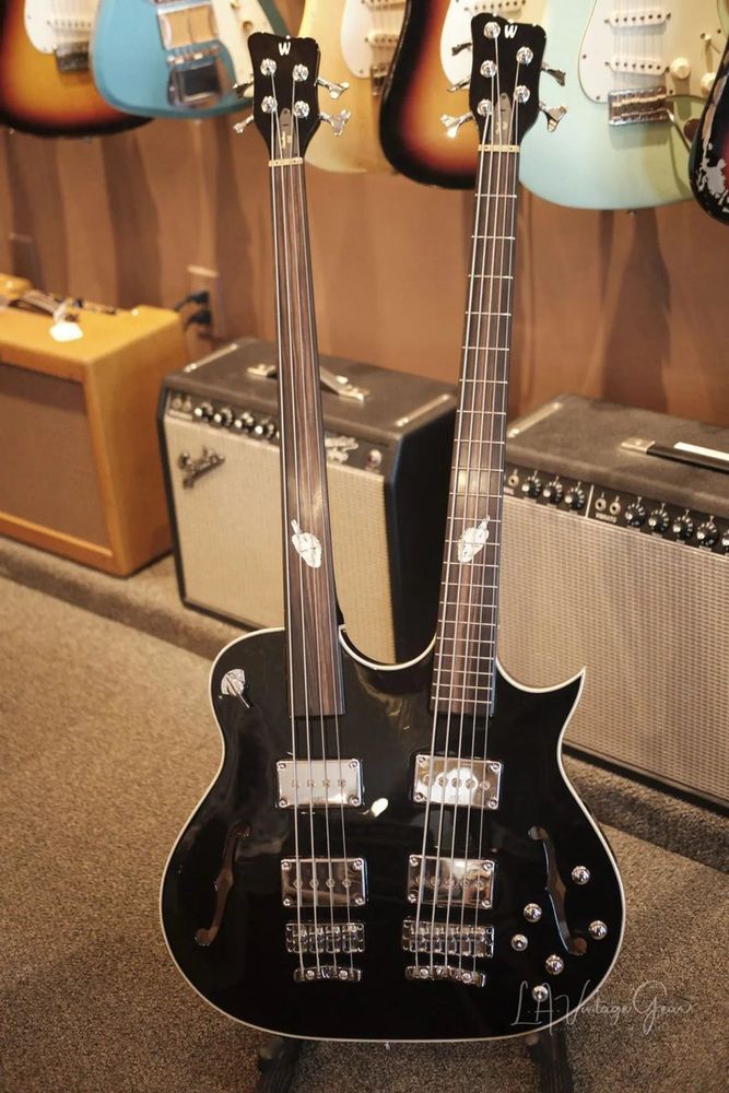 Here's a doubleneck bass Warwick made for Leland Sklar. It looks like a doubleneck hollowbody Les Paul with two F-holes. The top neck is a fretless 4-string, and the bottom neck is a fretted 5-string. Each neck has two fat single-coil pickups, and each neck has its own volume, tone control, and 3-way switch. There's also a 4-way rotary switch (top/both/bottom/mute) by the top neck. The only inlays on the necks are shaped like hands flipping you off.