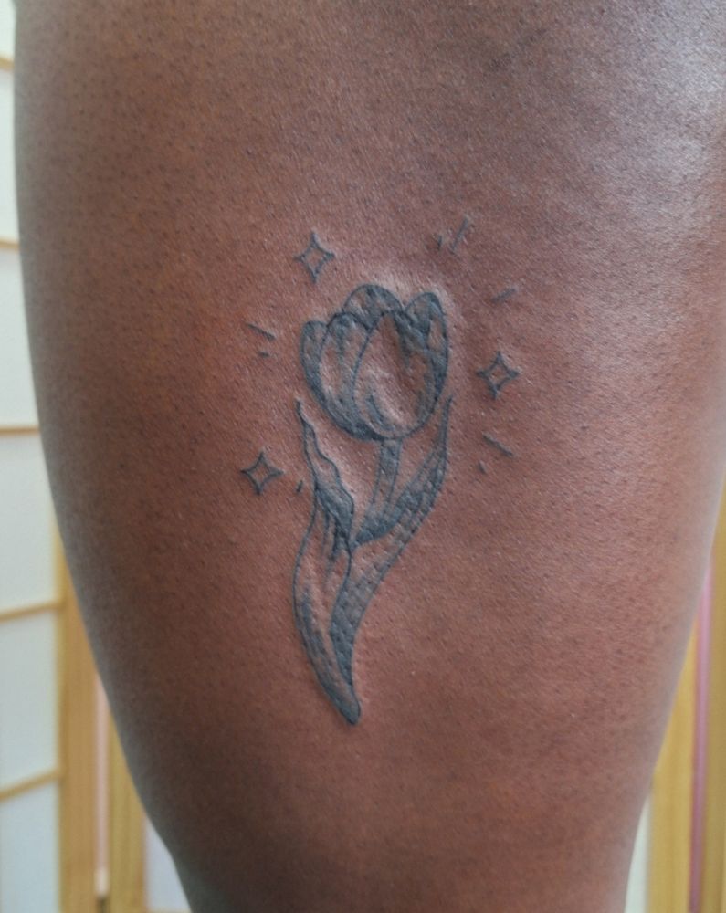 Tattoo of a tulip on the side thigh