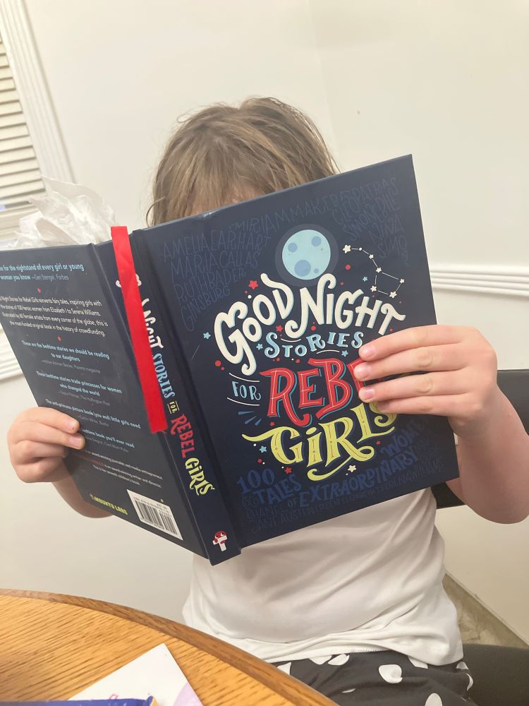 A young girl reads “good night stories for rebel girls”