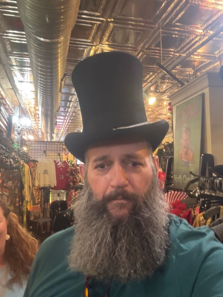 A heavily bearded doofus in a top hat. 