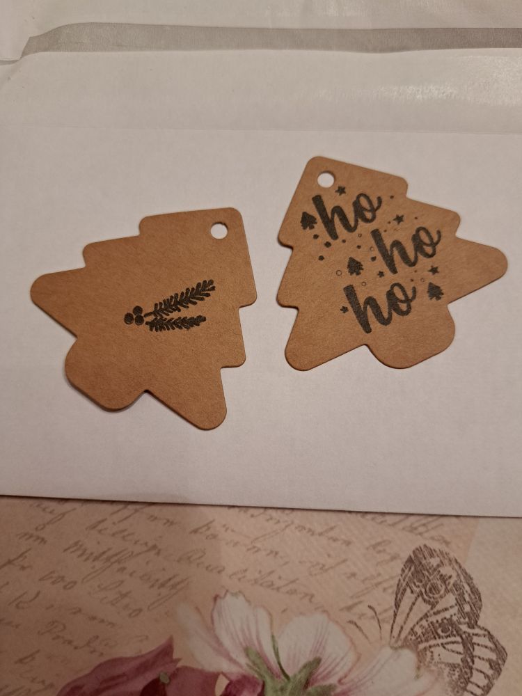 2 Anhänger aus kraftpapier in Baumform.  Einer mit Lettering "ho ho ho" , einer mit Tannenzweigen