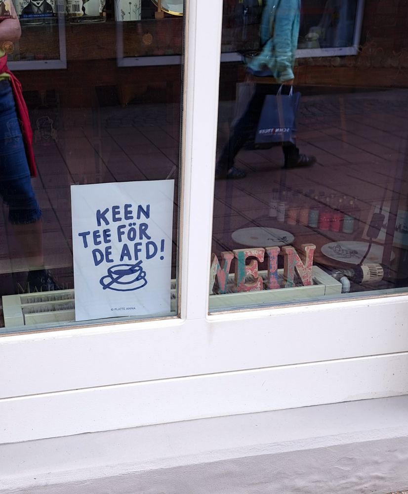 Schaufenster eines Tee- und Weinladens mit Plakat "Keen Tee för de Afd" in Varel
