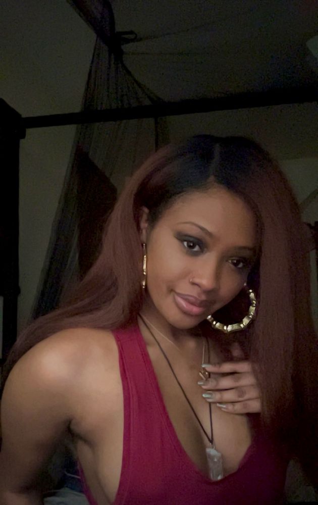 Yonn giving a more straightforward yet angled pose with large gold hoop earrings, a crystal necklace and a gold heart nevklace