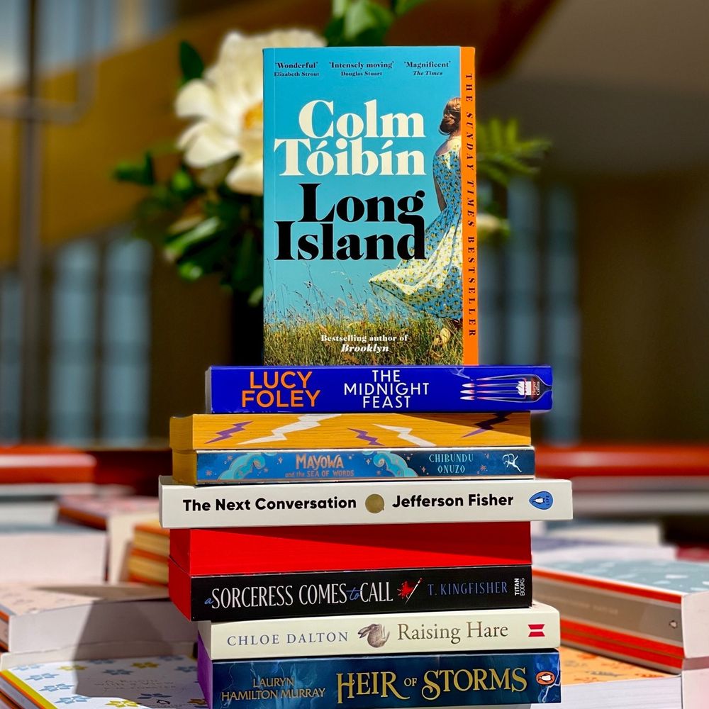 A pile of books on a bookshop table:
Colm Toibin's Long Island,
Lucy Foley's The Midnight Feast,
Chibundu Onuzo's Mayowa,
Jefferson Fisher's The Next Conversation,
T Kingfisher's A Sorceress COmes to Call,
Chloe Dalton's Raising Hare,
Lauryn Hamilton-Murray's Heir of Storms