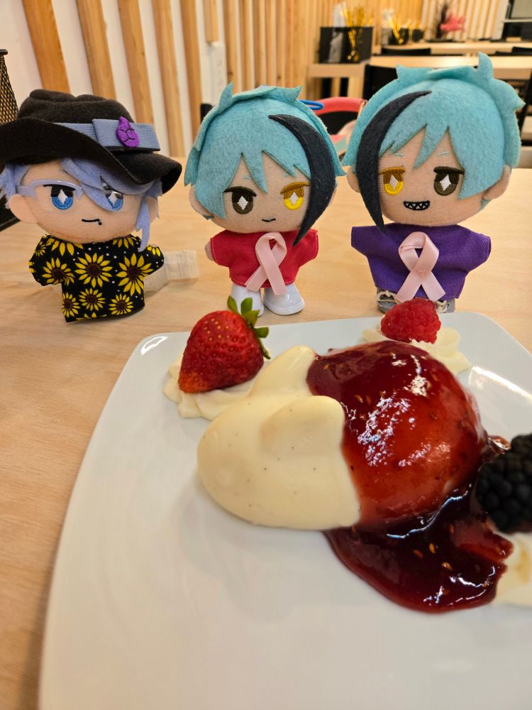 A Jade Leech nui, a Floyd Leech nui, and an Azul Ashengrotto nui standing by a plate with a bunny-shaped vanilla bean panna cotta topped with raspberry sauce