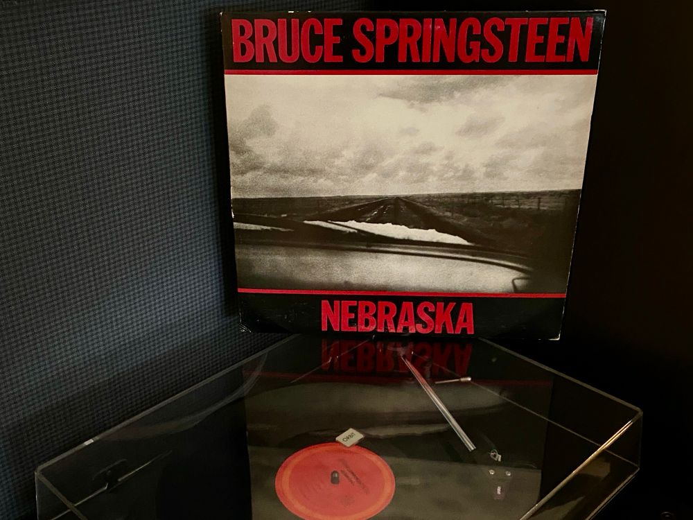 Nebraska • Bruce Springsteen • 1982 album cover on top of a record player playing the record 