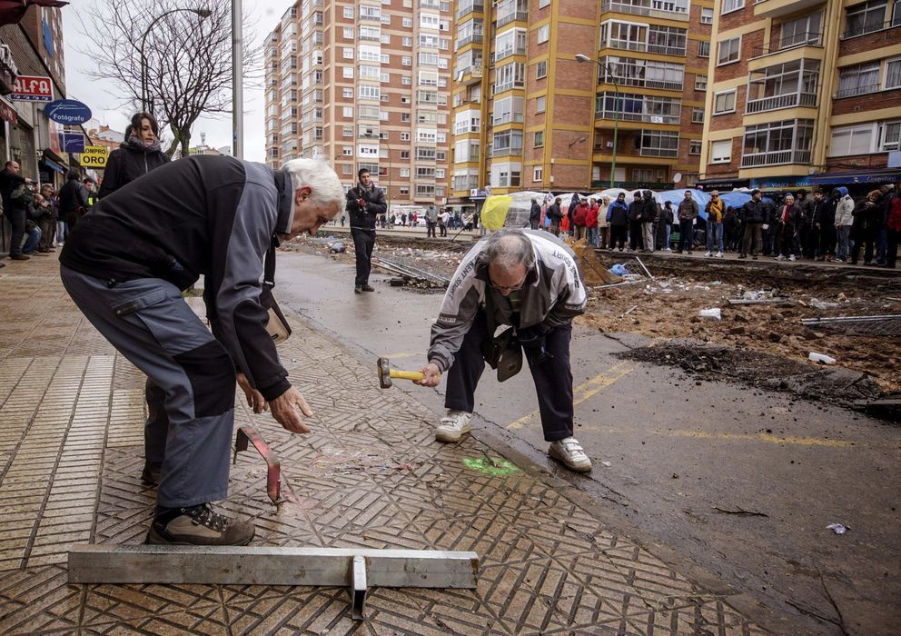 Vecinos del barrio (+70 años aprox.) picando el suelo para arrancar las baldosas 
