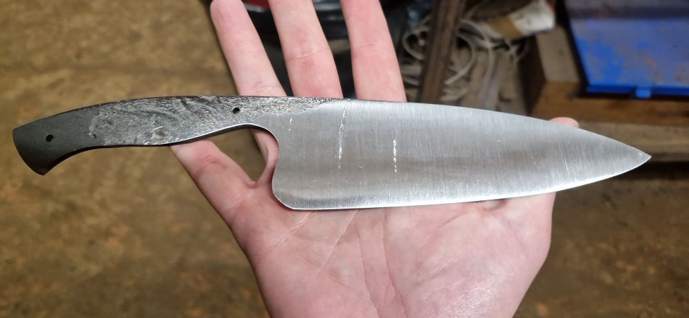 Gosh! That almost looks like a knife! The blade has been cleaned up and is fairly shiny. It is following a traditional European chefs knife pattern