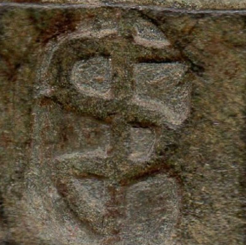 A brass apothecary's weight from the 1600s. It has a simplified image of a snake coiled around a staff embossed into the surface.