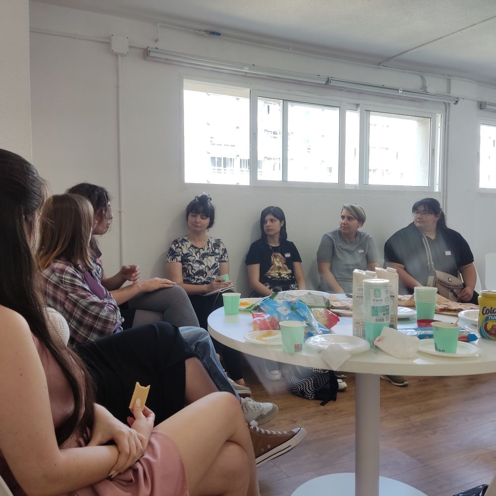 Varies asistentes del meetup de A Coruña de FemDevs hablando y comiendo rico (Sara llevó empanada vegana).