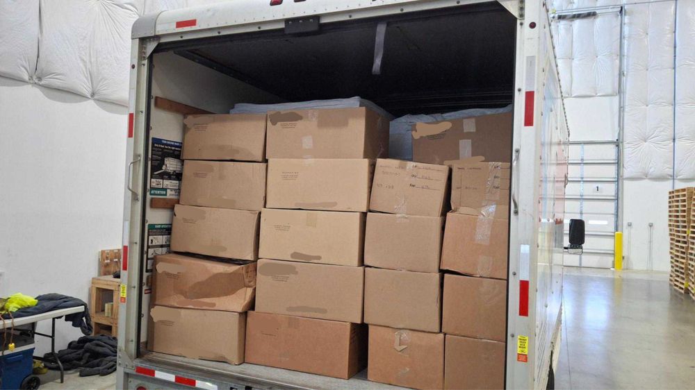 A photo of a number of boxes packed into the back of a box truck